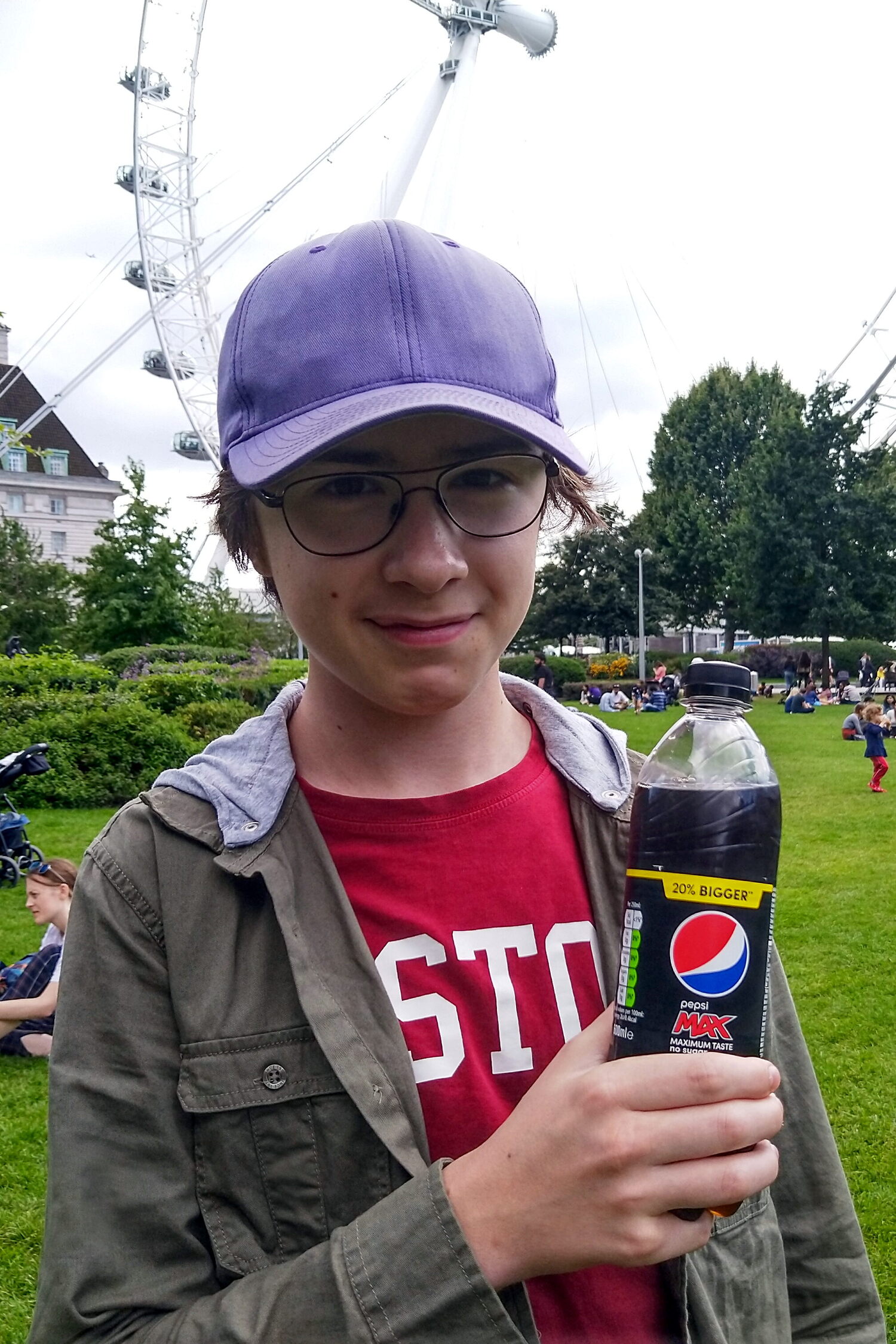 William framför Coca-Cola London Eye med en flaska Pepsi.