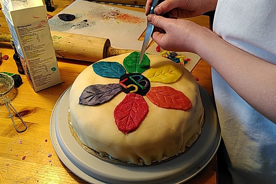 Tårta dekorerad med regnbågsblomma.