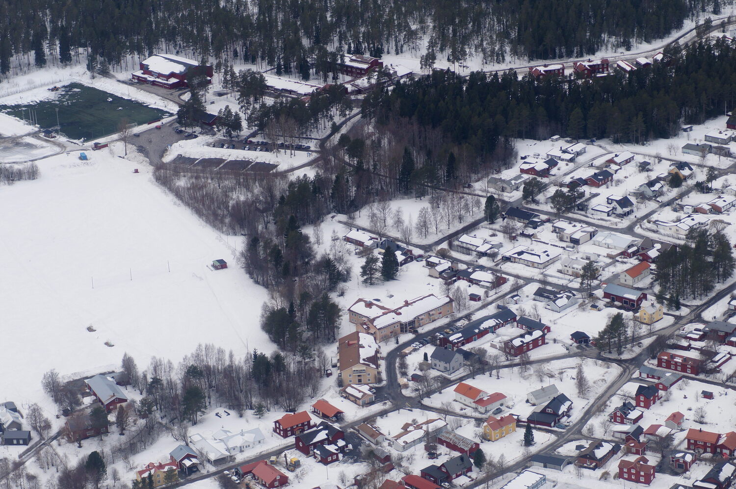 Vy över Röbäck med fotbollsplanen, Elofssonhallen och Linneaskolan längst upp till höger. Bäckbacka ungefär mitt i bilden.
